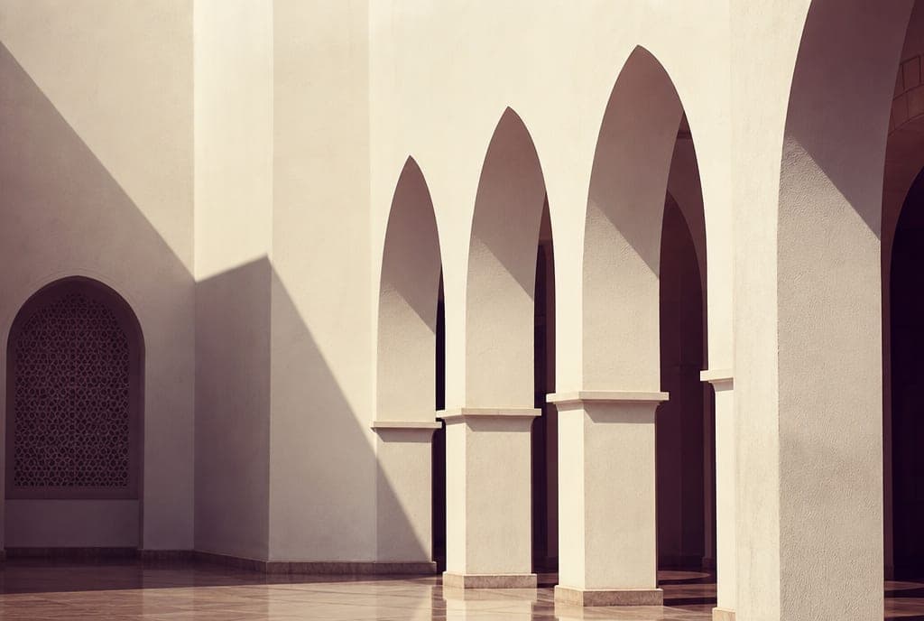 White pointed arches and a shaded arcade in morning light